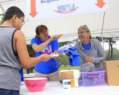 Foundation 153 Executive Director Shelley Peck, center, and District 153 school board President Shelly Marks check in a runner for the Fund Run 5K race.