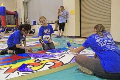 Sommer Owens, Nora Vargo and Raena Kaminski work together on a painting during the Foundation 153 fun fair.