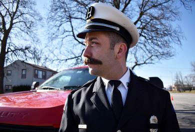 Nicholas Camilli from the Flossmoor Fire department watches the funeral of Chicago Heights fallen officer, Gary Hibbs. Camilli and Officer Hibbs were friends growing up. (MC)