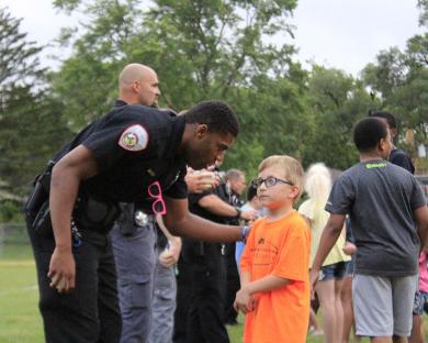 Homewood police officer Ephraim Dorsey offers some advice to his partner prior to the water balloon toss contest at National Night Out in Homewood.