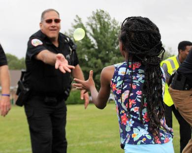 Homewood officer Dave Lux tosses a balloon during National Night Out.