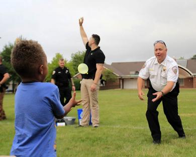 Homewood Deputy Police Chief Rick Sewell tosses a water balloon to his partner.