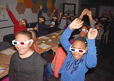 Wearing 3D glasses, Serena Hills second graders Aemilia Miranda, Saya Knazze and their classmates feel like they are taking a trip on a roller coaster while watching a video at Homewood's Science Center's Michael Wexler Theater. (MC)