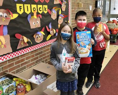Second graders at Willow School in Homewood, from left, Grace Garland, Max Escamilla and Mason Culbreath, joined with fellow students and staff collecting food over the past two weeks. The non-perishable items will be distributed to needy families this Thanksgiving by Open Access. (Marilyn Thomas/H-F Chronicle)