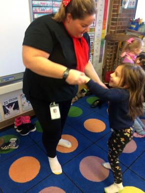 Kindergarten teacher Amy Brecheisen dances with a student at the Room 21 sock hop.
