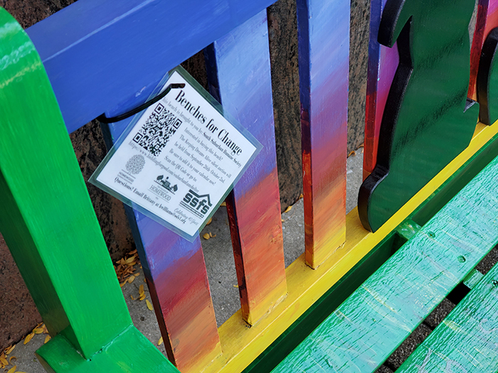 The South Suburban Humane Society bench has a tag attached with a QR code that can be scanned with a phone to find out how to bid on the bench. All the benches on display throughout downtown Homewood are tagged to help supporters of the South Suburban Family Shelter with its fundraising project. (Eric Crump/H-F Chronicle)