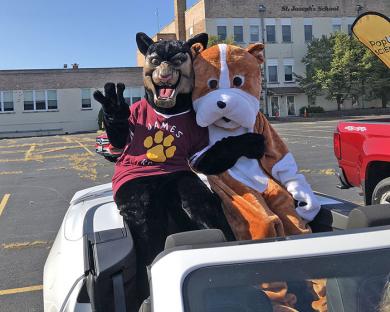 Two of the District 153 mascots — James Hart's panther and Churchill's bulldog — get ready for their drive through Homewood.