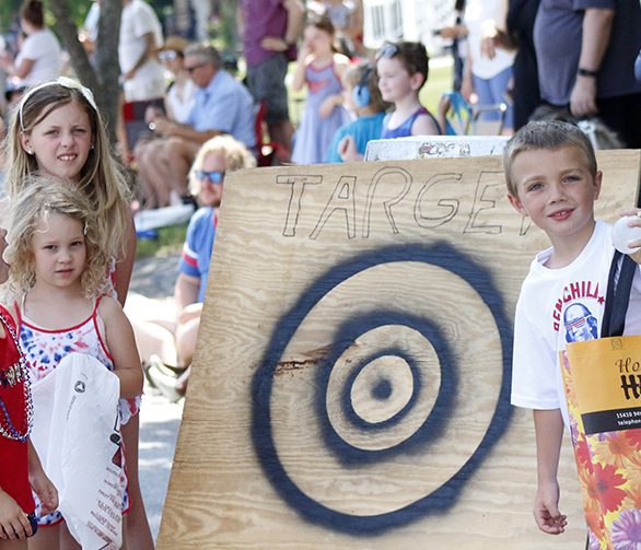 From left, Chloe Calderon, Olivia and Giana Rostoker and James Calderon try to entice parade participants to take aim at their candy-collecting target. James explained that the kids hoped to get "all the candy" with their target. (EC)