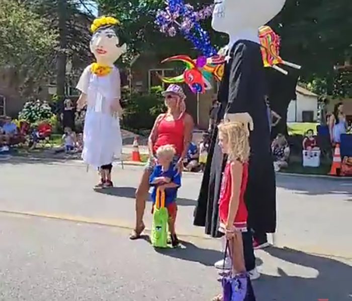 Robbi Hameister poses with her grandchildren Charlee, Wyatt and Gregory next to a Day of the Dead character created by local artist Xicantl. (EC)