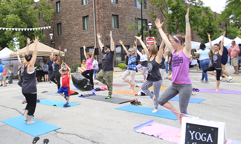 Liz Smith, owner of Serendipity Yoga and Wellness, leads an outdoor yoga session at the 2019 Homewood Artisan Street Fair. Smith is the lead organizer of the Healthy Homewood Festival July 16 on Martin Avenue. (Chronicle file photo)