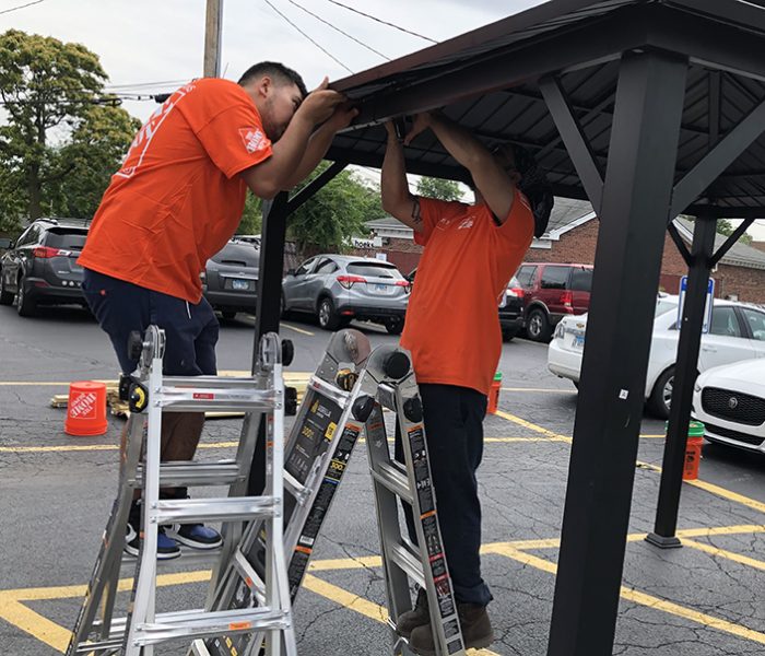 Homewood Home Depot employees Luis Hernandez and Uriel Biurcos assemble a gazebo for the Cancer Support Center. (Marilyn Thomas/H-F Chronicle)