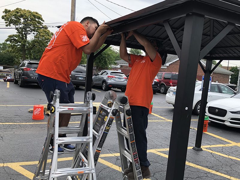 Homewood Home Depot employees Luis Hernandez and Uriel Biurcos assemble a gazebo for the Cancer Support Center. (Marilyn Thomas/H-F Chronicle)