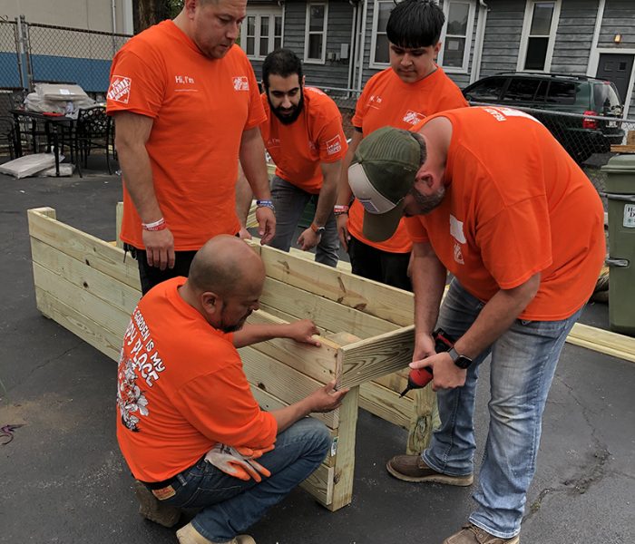 A team of Home Depot employees work at assembling a standing flower bed frame to be used at the Homewood Cancer Support Center. (Marilyn Thomas/H-F Chronicle)