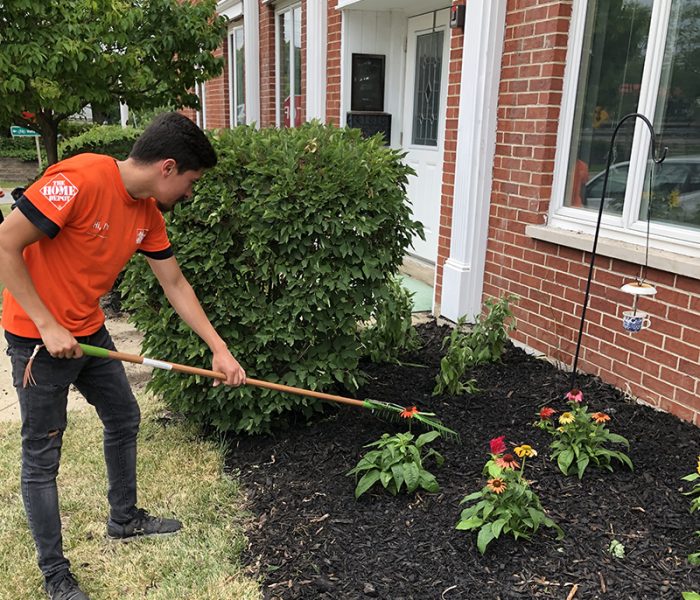 Alberto Bravo, a Home Depot employee working in Calumet City, helped put finishing touches on a flower bed in front of the Cancer Support Center in Homewood. (Marilyn Thomas/H-F Chronicle)