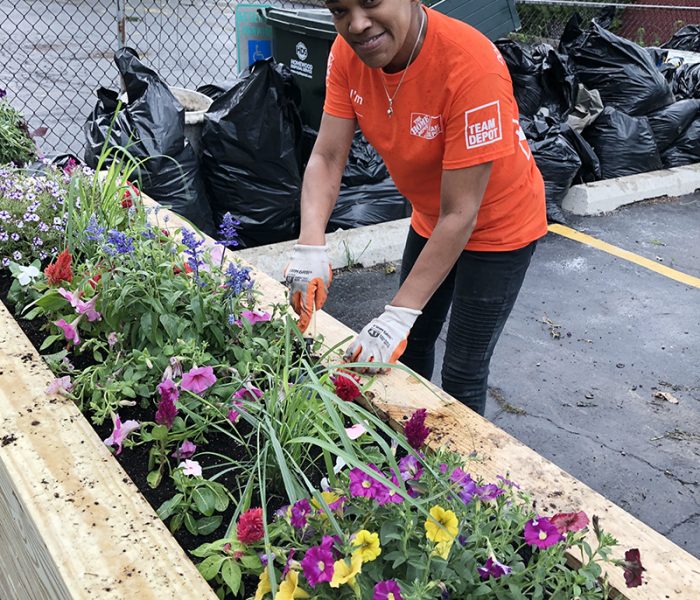 Tara Robinson, an employee at the Homewood Home Depot, finishes planting in a new flower box built by her co-workers for the Cancer Support Center in Homewood. Robinson's mother, Sandria Robinson, has recently been a Cancer Support Center client. (Marilyn Thomas/H-F Chronicle)