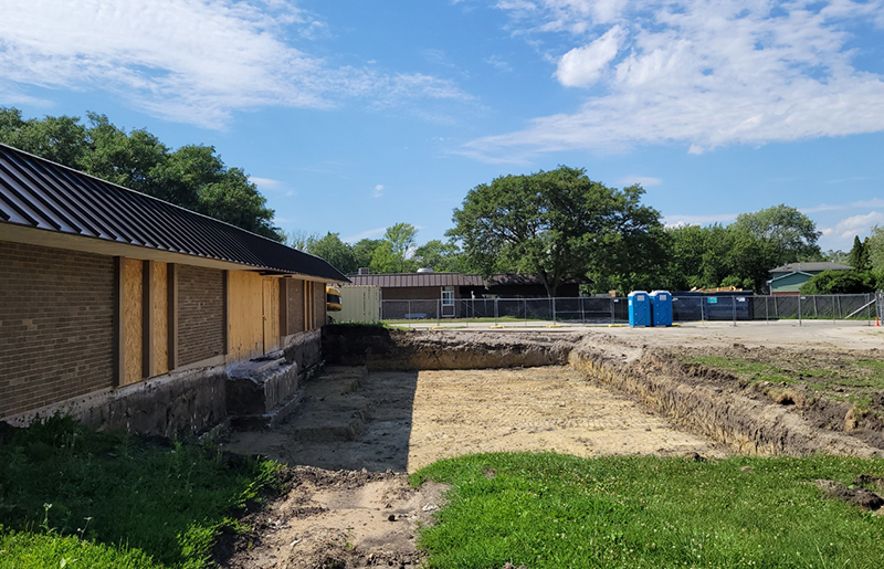 The hole is dug, but construction work has stopped for now at Church School in Homewood. A strike affecting asphalt production in the region has slowed or stopped many summer projects. (Eric Crump photos/H-F Chronicle)