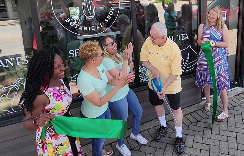 Homewood Mayor Richard Hofeld helps mother-daughter owners Denise Rhodes and Amanda Battle cut the ribbon to mark the opening of their botanical and wellness shop, Roots + Fire Water, on Saturday, July 2. Homewood Trustee Cece Belue, left, and Economic Development Director Angela Mesaros, right, look on. (Eric Crump/H-F Chronicle)