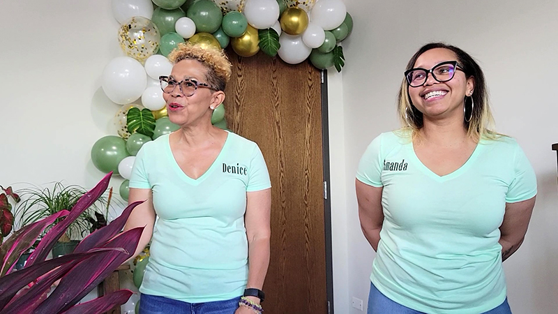 The mother-daughter team who founded Roots + Fire Water, Denice Rhodes, left, and Amanda Battles, speak at the grand opening on July 2. (Eric Crump/H-F Chronicle)