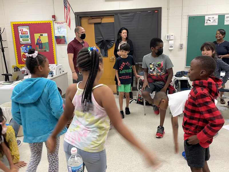 Third-grade Summer Academy students take a "wiggle break" while watched by their teacher, Andrew Fine, from left, assistant principal Pam Panozzo, and principal Evita McNeil. (Carole Sharwarko/H-F Chronicle)