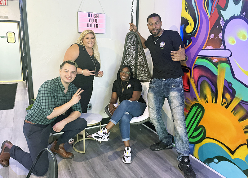 From left, management trainer Sean Garcia-Kalusa, Wake-N-Bank co-founder Brianna Banks, Homewood franchisee owners Jeree Ford and Jonathan Thornton pose in front of the hammock inside Wake-N-Bake. (Nick Ulanowski/H-F Chronicle)