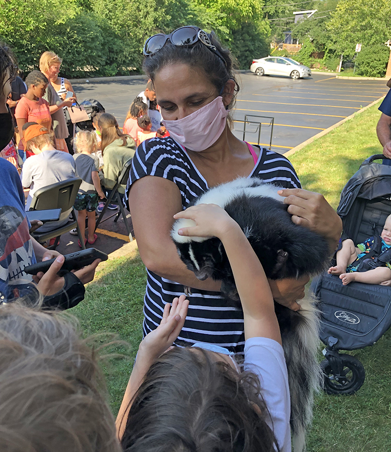Jessica Lopez holds the striped skunk given kids a chance to pet the animal. (Marilyn Thomas/H-F Chronicle)