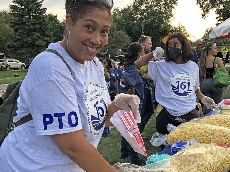 LaCael Pratt, a volunteer with the District 161 Parent-Teacher Organization, was serving popcorn to guests at the Back to School event at Flossmoor Park. (Marilyn Thomas/H-F Chronicle)