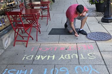 Nico Martinez gets his messages out in front of Dunning's Market in Flossmoor on Wednesday as part of the District 161 Chalk the Walk project. (Marilyn Thomas/H-F Chronicle)