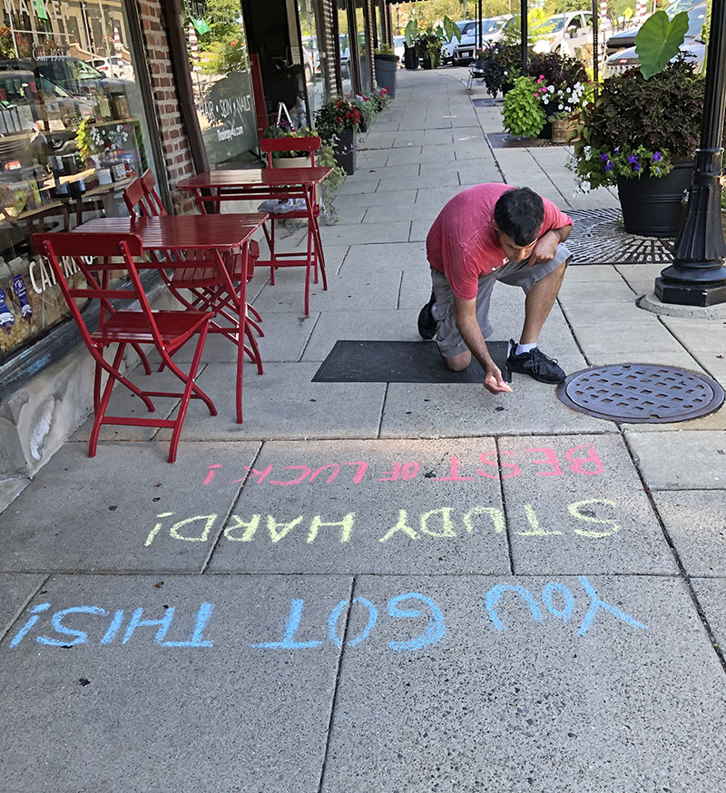 Nico Martinez gets his messages out in front of Dunning's Market in Flossmoor on Wednesday as part of the District 161 Chalk the Walk project. (Marilyn Thomas/H-F Chronicle)