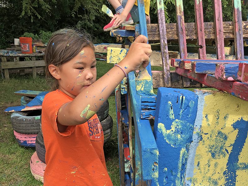 Emilia Leahy gets busy applying blue paint to her team's structure. (Marilyn Thomas/H-F Chronicle)