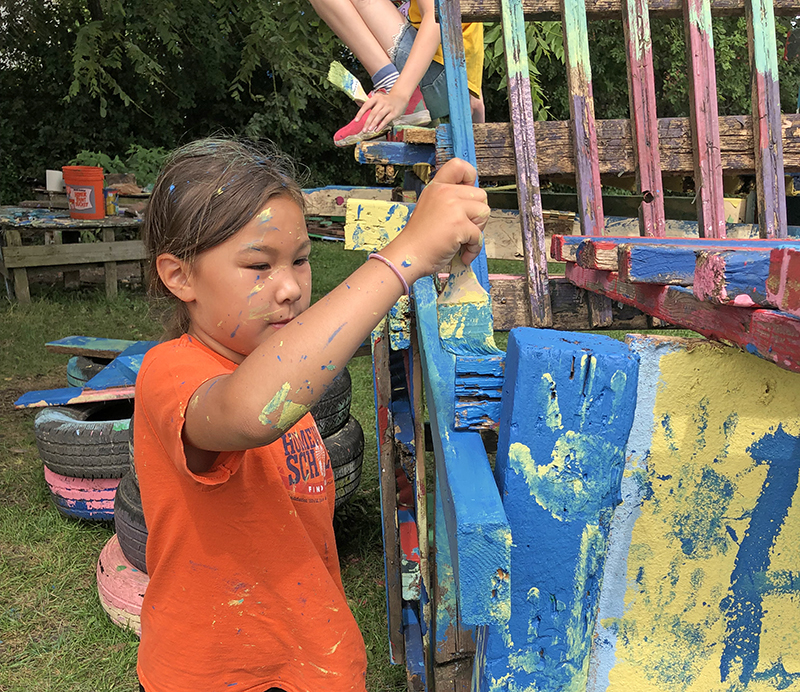 Emilia Leahy gets busy applying blue paint to her team's structure. (Marilyn Thomas/H-F Chronicle)