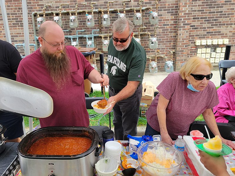 Brian Reichard, left, serves up a bowl of his first-place chili during Homewood's Fall Fest. (Eric Crump/H-F Chronicle)