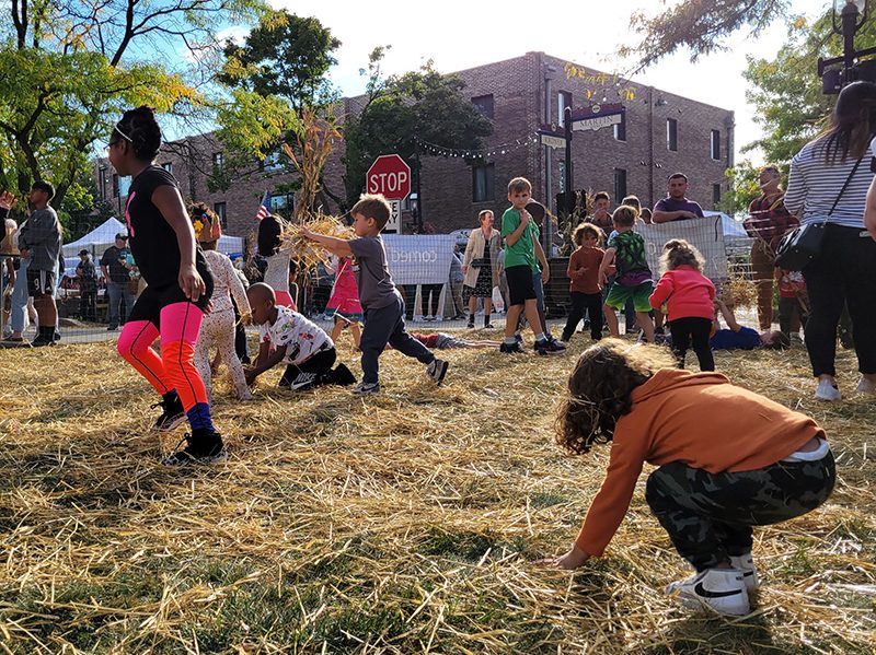 It's the simple things. Kids enjoy playing with straw strewn on the Gottschalk house lawn. (Eric Crump/H-F Chronicle)
