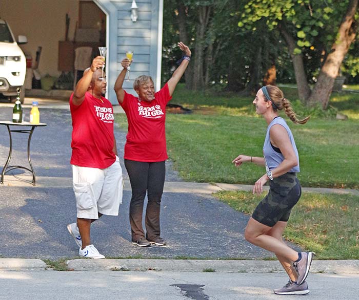 Flossmoor residents cheer a runner passing their home during the 2021 Hidden Gem Half Marathon. (Chronicle file photo)