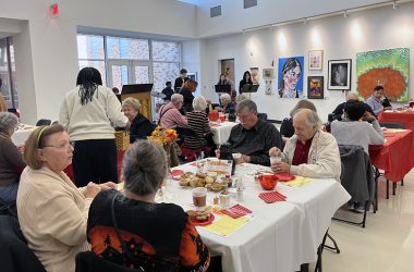 Senior citizens eat breakfast as guests of Homewood-Flossmoor High School while Miyako, a jazz ensemble that consists of H-F students, performs in the background. (Nick Ulanowski/H-F Chronicle)