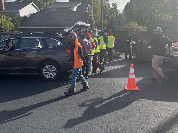 Lalinda De La Fuente looks out her car window as student volunteers unload the donations from her trunk during Recyclepalooza on Oct. 8. (Nick Ulanowski/H-F Chronicle)