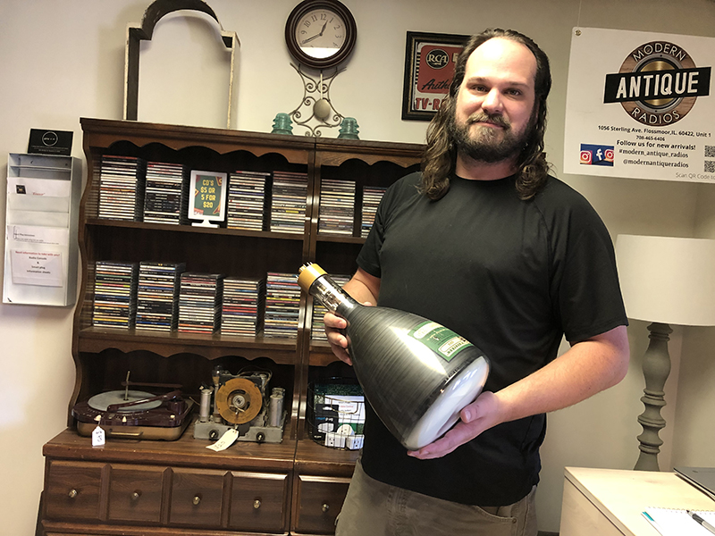 Jason Youngberg holds an old television tube. He turned a similar tube into a TV with Blue Tooth. His store Modern Antique Radios features old equipment and some converted pieces, as well as vinyl records and CDs. (Marilyn Thomas/H-F Chronicle)