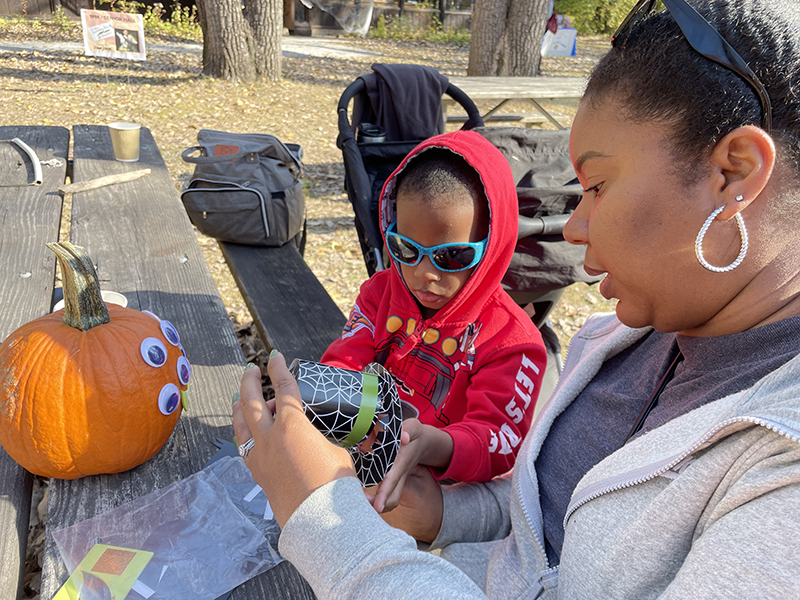 Tawny Falae, of Homewood, decorates a pumpkin with her son Joshua, 3, during Homewood Science Center’s 2022 Walk Walton at Homewood Izaak Walton Preserve. (Bill Jones/H-F Chronicle)