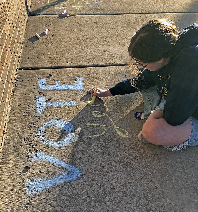 Teagan Meeks, a seventh grader at James Hart School, puts her Vote Yes message along the sideway on Harwood Avenue in Homewood reminding voters to support the District 153 schools referendum Tuesday. (Marilyn Thomas/H-F Chronicle)
