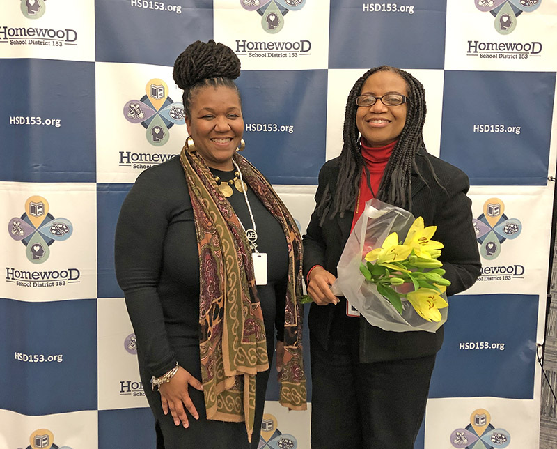 Melanie Mandisodza, left, director of special education in Homewood District 153, offers her congratulations to school psychologist Sharon Perry on her completion of a doctorate degree in school psychology. (Marilyn Thomas/H-F Chronicle)