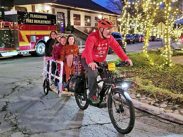 Chris Bednarek gives a group of singing youngsters a ride around the traffic island. (Eric Crump/H-F Chronicle)