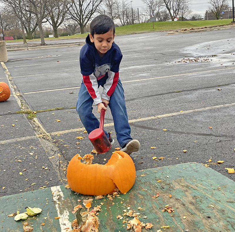 Norberto Tovalin, 8, of Glenwood, busts open a pumpkin with a mallet on Saturday, Nov. 5, in the parking lot of Coyote Run Golf Course as part of the annual Pumpkin Smash. (Bill Jones/H-F Chronicle)
