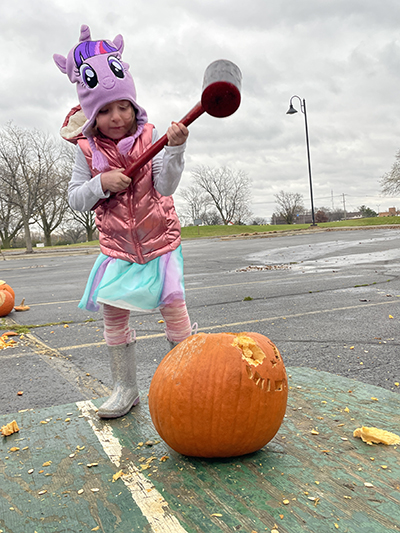 Therese Nutley, 5, of Homewood, raises the hammer to lay waste to a gourd during the Pumpkin Smash on Saturday, Nov. 5, at Coyote Run Golf Course in Flossmoor. (Bill Jones/H-F Chronicle)