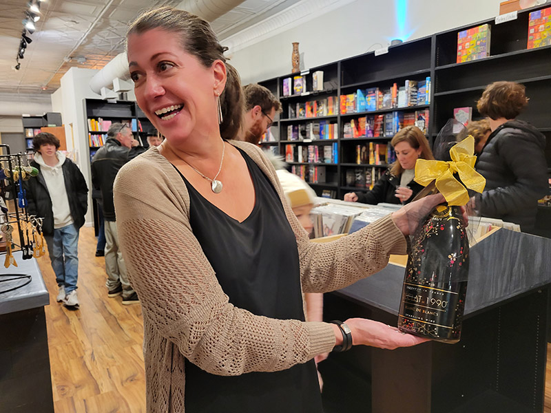 Laura Bruni, co-owner of the Rockshop, with a bottle of bubbly given to her by a well-wisher at the soft opening of the shop. (Eric Crump/H-F Chronicle)