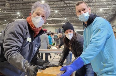 From left, Jackie Riffice, Stephanie Wright and Dave King pull a side rail from a stain solution during the Build-a-Bed event Jan. 16. (Eric Crump/H-F Chronicle)