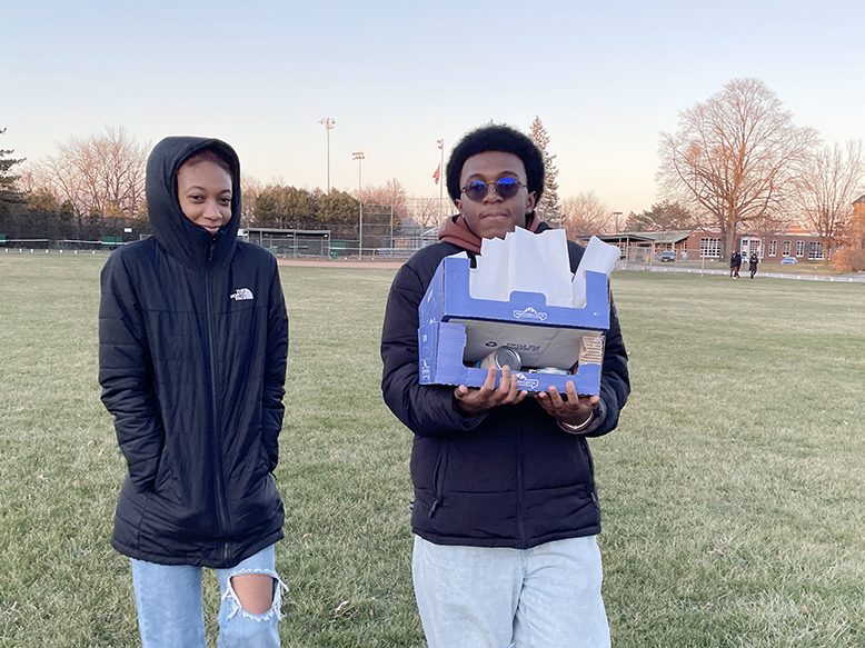 Homewood-Flossmoor High School students Taleah Spurling and Jered Maltbia walk across Flossmoor Park while helping the Flossmoor Service League set up luminaries. (Bill Jones/H-F Chronicle)