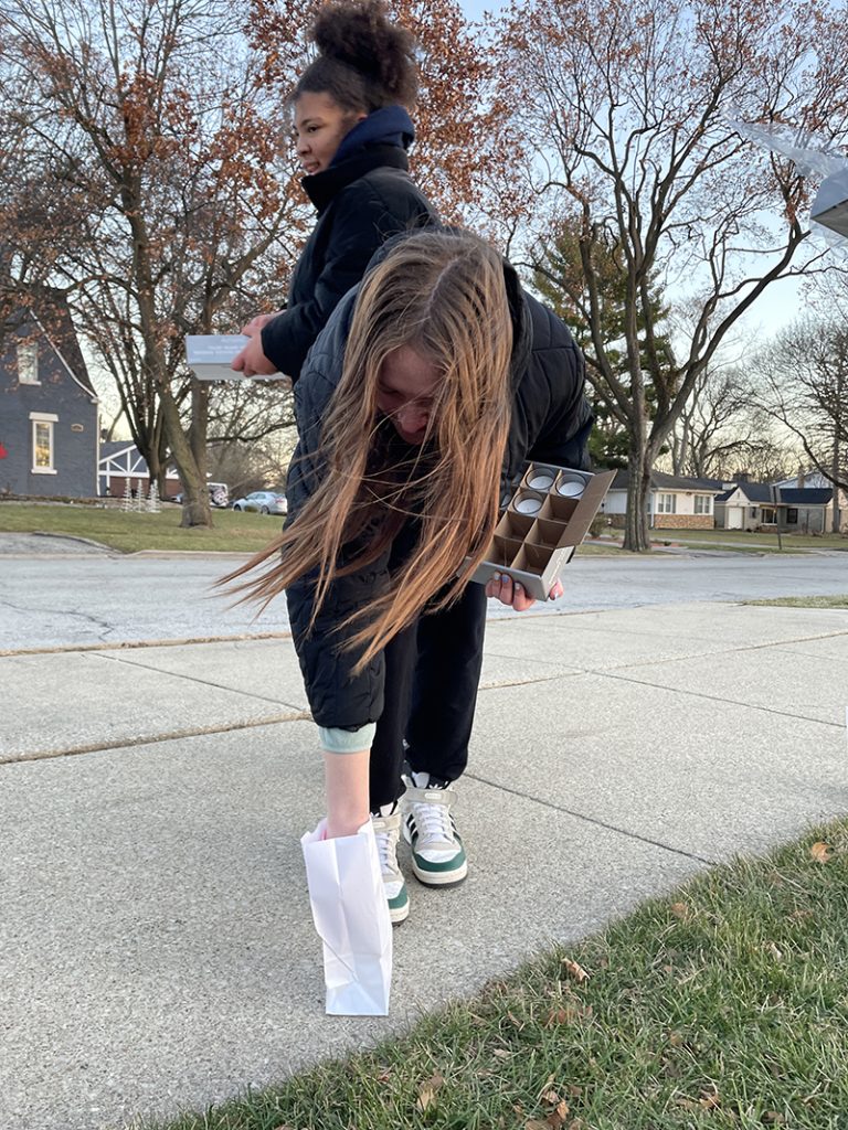 Violet Quirke, a National Honor Society student at Homewood-Flossmoor High School, places candles in bags on Thursday, Dec. 1, around Flossmoor Park. (Bill Jones/H-F Chronicle)