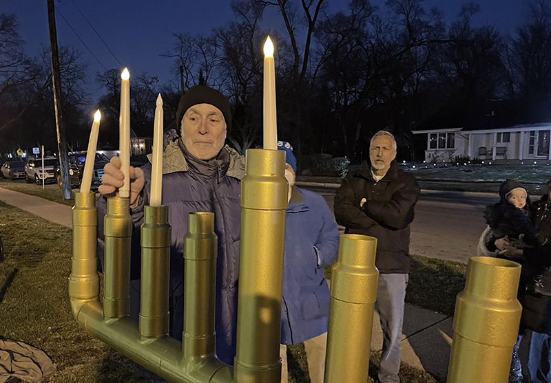 Jeffrey Lippert, of Flossmoor, lights the candles on the menorah at Flossmoor Park on Tuesday, Dec. 20, during the village’s public celebration of the third night of Hanukkah. (Bill Jones/H-F Chronicle)