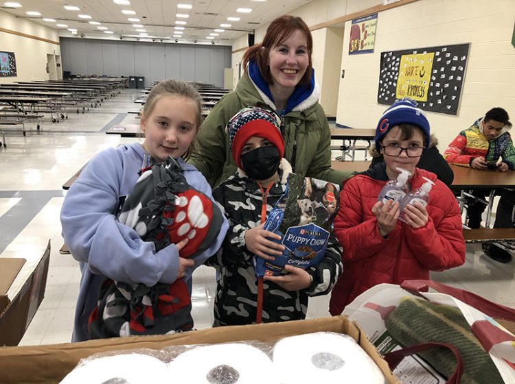 Churchill School students, from left, Cora Donohue Alex Castellanos and Ollie Green and teacher Karen Lindquist help pack up Items for the dogs and cats at the South Suburban Human Society. The students worked as members of the Early Act Club at Churchill during Homewood District 153's Martin Luther King Jr Day of Service event. (Marilyn Thomas/H-F Chronicle)