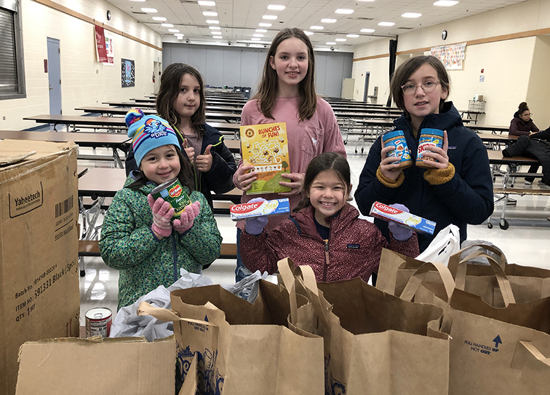 Sorting some of the donations at the District 153 drop-off site are, front row left, Fiona Negrette and Lyla Negrette, right, students at Churchill School, and, back row from left, Henry Eisenberg, Chloe Schneider and Natalie Popelka, students at James Hart School. (Marilyn Thomas/H-F Chronicle)