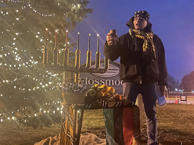 Leonard Harris, of Flossmoor, lifts a cup with what would typically be shared communal libations on Saturday, Dec. 31, during the sixth night of Kwanzaa. (Bill Jones/H-F Chronicle)